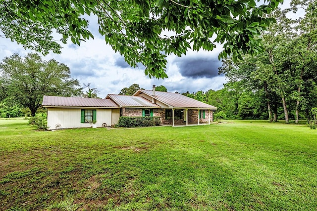 single story home featuring metal roof and a front yard
