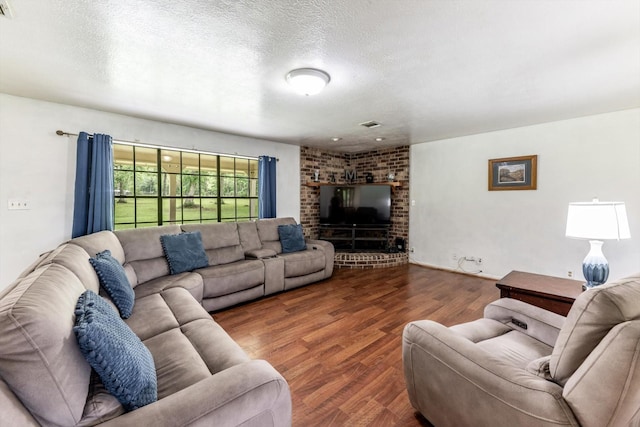 living room with a textured ceiling, visible vents, and wood finished floors