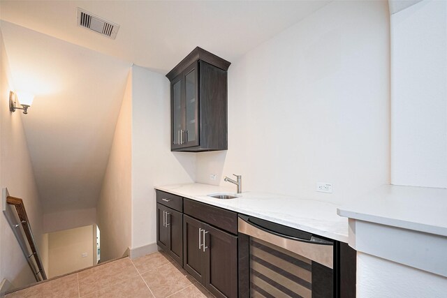 bar featuring beverage cooler, visible vents, a sink, and light tile patterned floors