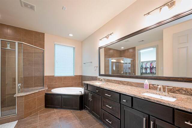 bathroom featuring a sink, tile patterned flooring, a stall shower, and visible vents