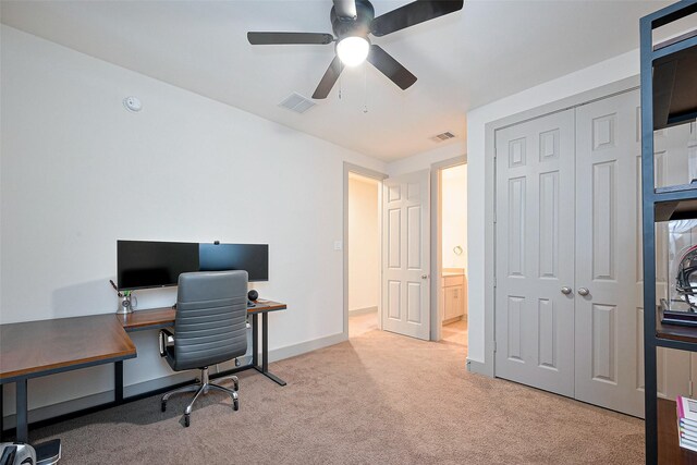 office space with visible vents, baseboards, ceiling fan, and light carpet