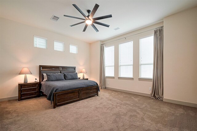 carpeted bedroom with a ceiling fan, baseboards, and visible vents