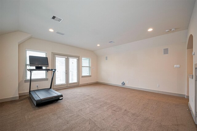 exercise area with visible vents, carpet, and vaulted ceiling