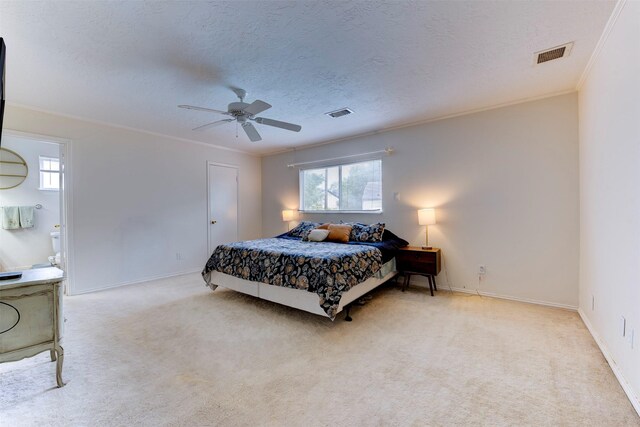 bedroom with crown molding, baseboards, carpet floors, and visible vents