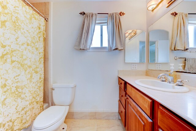 bathroom featuring toilet, baseboards, shower / tub combo with curtain, and vanity