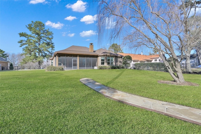 73 La Jolla Cir, Montgomery, TX 77356 - rear view of property featuring a lawn, a chimney, and a sunroom