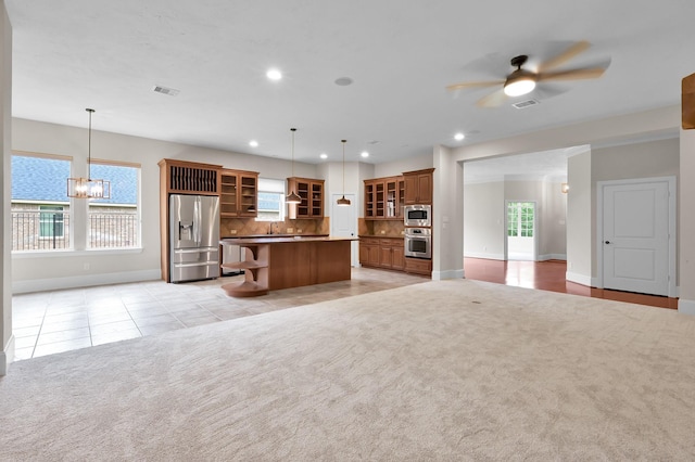 73 La Jolla Cir, Montgomery, TX 77356 - kitchen with brown cabinets, open shelves, ceiling fan with notable chandelier, stainless steel appliances, and baseboards