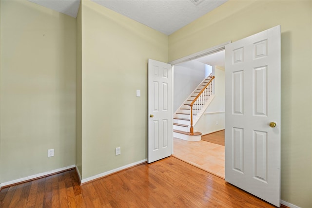 4614 Ringrose Dr, Missouri City, TX 77459 - unfurnished room with stairway, baseboards, and wood finished floors