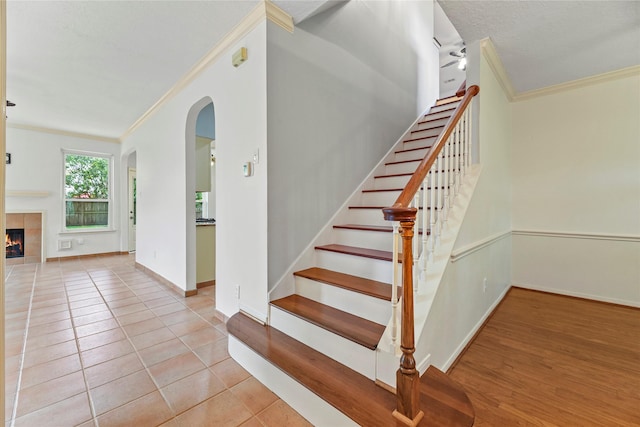 4614 Ringrose Dr, Missouri City, TX 77459 - stairway with crown molding, arched walkways, baseboards, and tile patterned floors