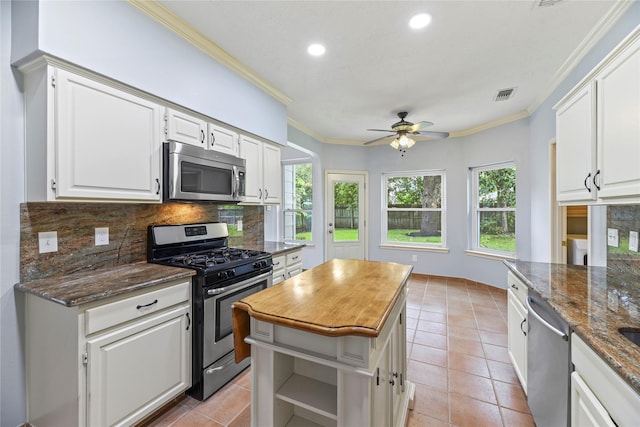 4614 Ringrose Dr, Missouri City, TX 77459 - kitchen featuring decorative backsplash, ornamental molding, recessed lighting, white cabinetry, and appliances with stainless steel finishes