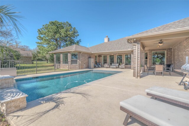 view of swimming pool featuring a fenced in pool, fence, a patio, and ceiling fan