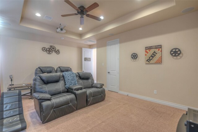 carpeted home theater room with visible vents, baseboards, ceiling fan, recessed lighting, and a raised ceiling