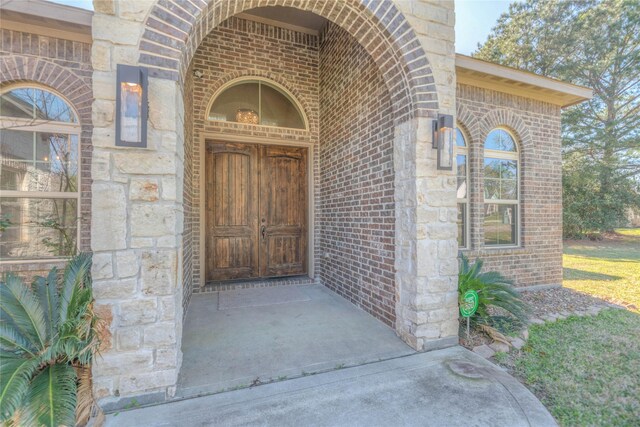 entrance to property with brick siding and stone siding
