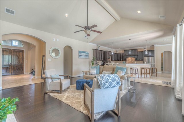living room with a ceiling fan, visible vents, arched walkways, high vaulted ceiling, and beamed ceiling