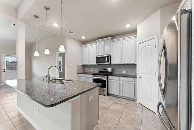 kitchen featuring visible vents, light tile patterned flooring, a sink, backsplash, and stainless steel appliances