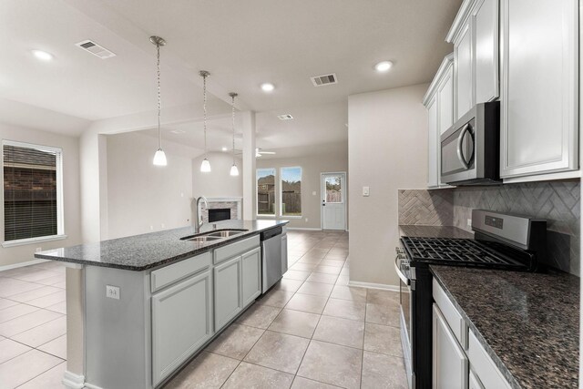 kitchen featuring visible vents, a sink, appliances with stainless steel finishes, and a fireplace