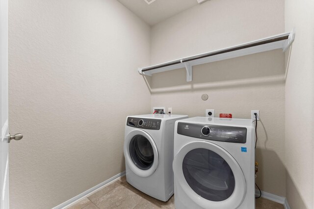 washroom with laundry area, baseboards, and independent washer and dryer
