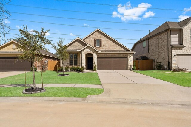 view of front facade with an attached garage, brick siding, a front yard, and concrete driveway