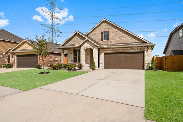 view of front facade with fence, concrete driveway, brick siding, and a front yard