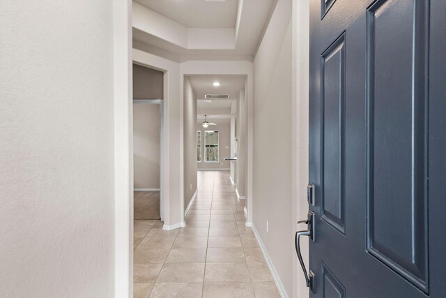 foyer entrance with visible vents, a ceiling fan, baseboards, and light tile patterned floors