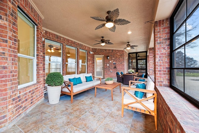 sunroom with an outdoor living space, a ceiling fan, and a wealth of natural light