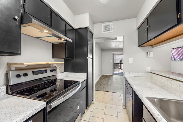 206 Plaza Verde Dr Unit D35, Houston, TX 77038 - kitchen with visible vents, extractor fan, electric stove, dark cabinets, and light tile patterned flooring