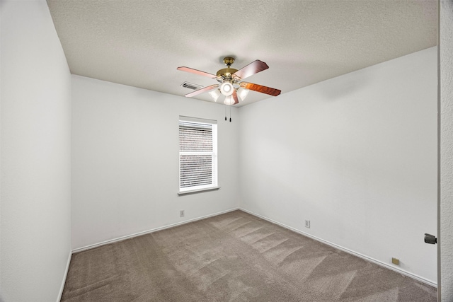 spare room featuring a ceiling fan, carpet flooring, a textured ceiling, and visible vents