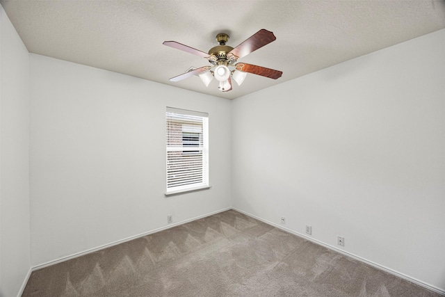 unfurnished room with carpet floors, a ceiling fan, and baseboards