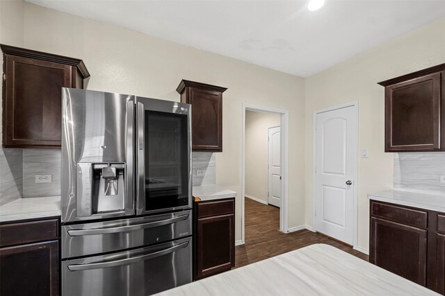 kitchen featuring light countertops, dark brown cabinetry, stainless steel refrigerator with ice dispenser, and dark wood finished floors