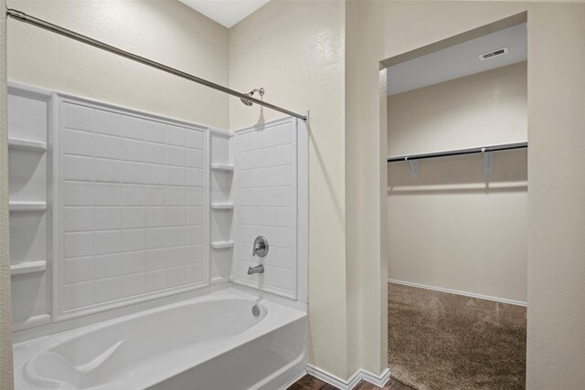 bathroom featuring visible vents, a textured wall, shower / washtub combination, and a spacious closet