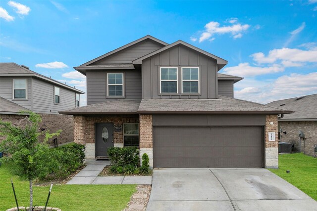 view of front of house with board and batten siding, a front yard, a garage, central AC, and concrete driveway