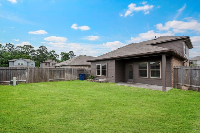rear view of house featuring a yard, a fenced backyard, and a patio area