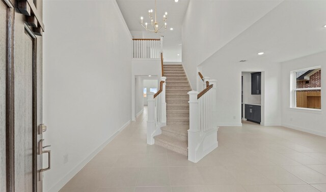 entryway with stairs, light tile patterned flooring, and a notable chandelier