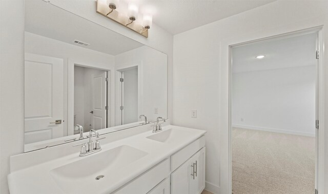 full bath with visible vents, a sink, baseboards, and double vanity