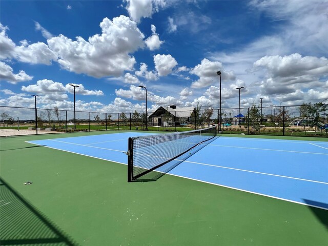view of tennis court with fence and community basketball court