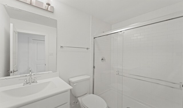 full bath featuring vanity, a shower stall, and toilet