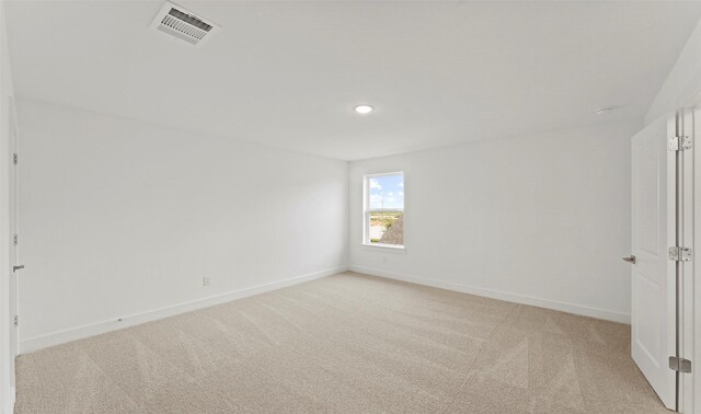 unfurnished bedroom featuring baseboards, light colored carpet, and visible vents