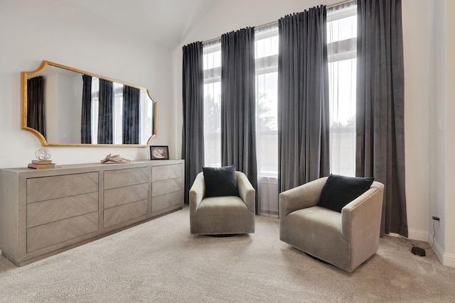 sitting room with baseboards, light carpet, and lofted ceiling