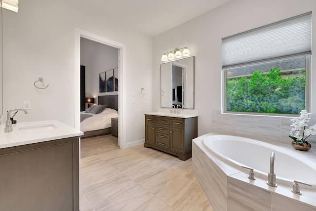 bathroom featuring ensuite bathroom, two vanities, a sink, and a bath