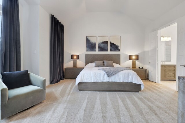 bedroom with carpet floors, vaulted ceiling, and ensuite bathroom