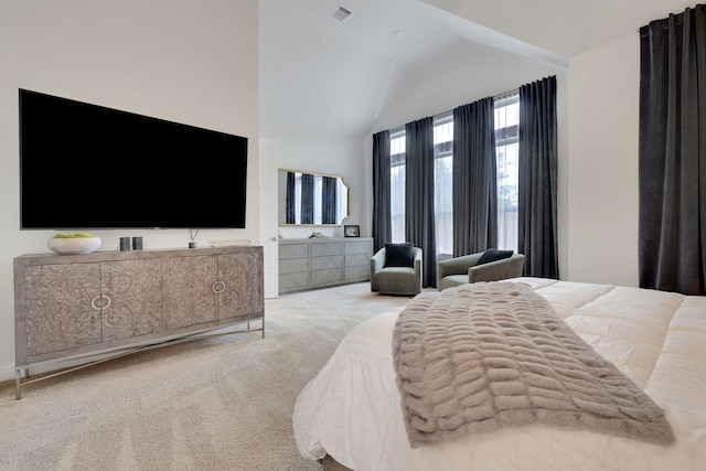 carpeted bedroom with visible vents and vaulted ceiling