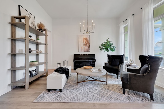 sitting room with an inviting chandelier, baseboards, and wood finished floors