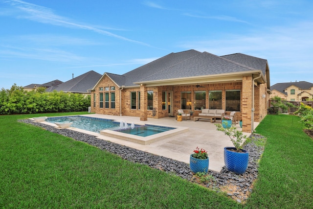 back of property with ceiling fan, a patio, an outdoor hangout area, brick siding, and a yard