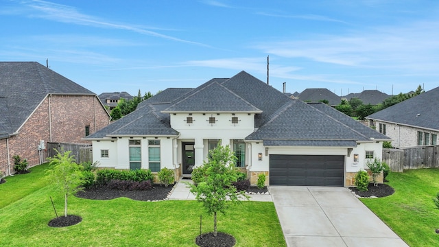 french country home featuring an attached garage, fence, driveway, and a front yard