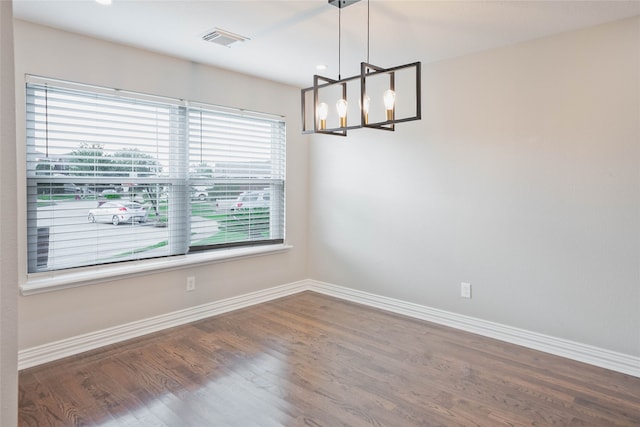 unfurnished room with an inviting chandelier, baseboards, a wealth of natural light, and visible vents