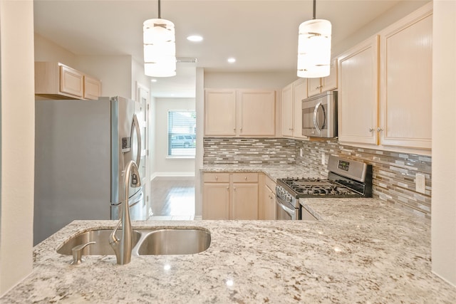kitchen featuring decorative backsplash, recessed lighting, light stone counters, a sink, and stainless steel appliances