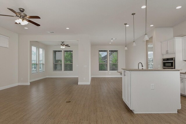 249 Palomino Ct, The Woodlands, TX 77382 - kitchen with open floor plan, a ceiling fan, recessed lighting, light wood-type flooring, and white cabinets