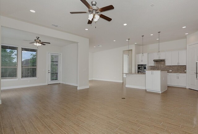 249 Palomino Ct, The Woodlands, TX 77382 - unfurnished living room featuring a ceiling fan, recessed lighting, light wood-style floors, and baseboards