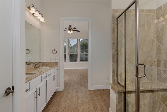 249 Palomino Ct, The Woodlands, TX 77382 - bathroom with a ceiling fan, a stall shower, wood finished floors, double vanity, and baseboards