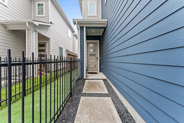 property entrance with fence and a lawn